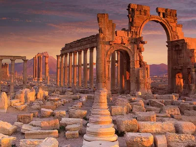 The Monumental Arch and colonnade of Palmyra at sunset — Syria has no McDonald's, so no Big Mac price